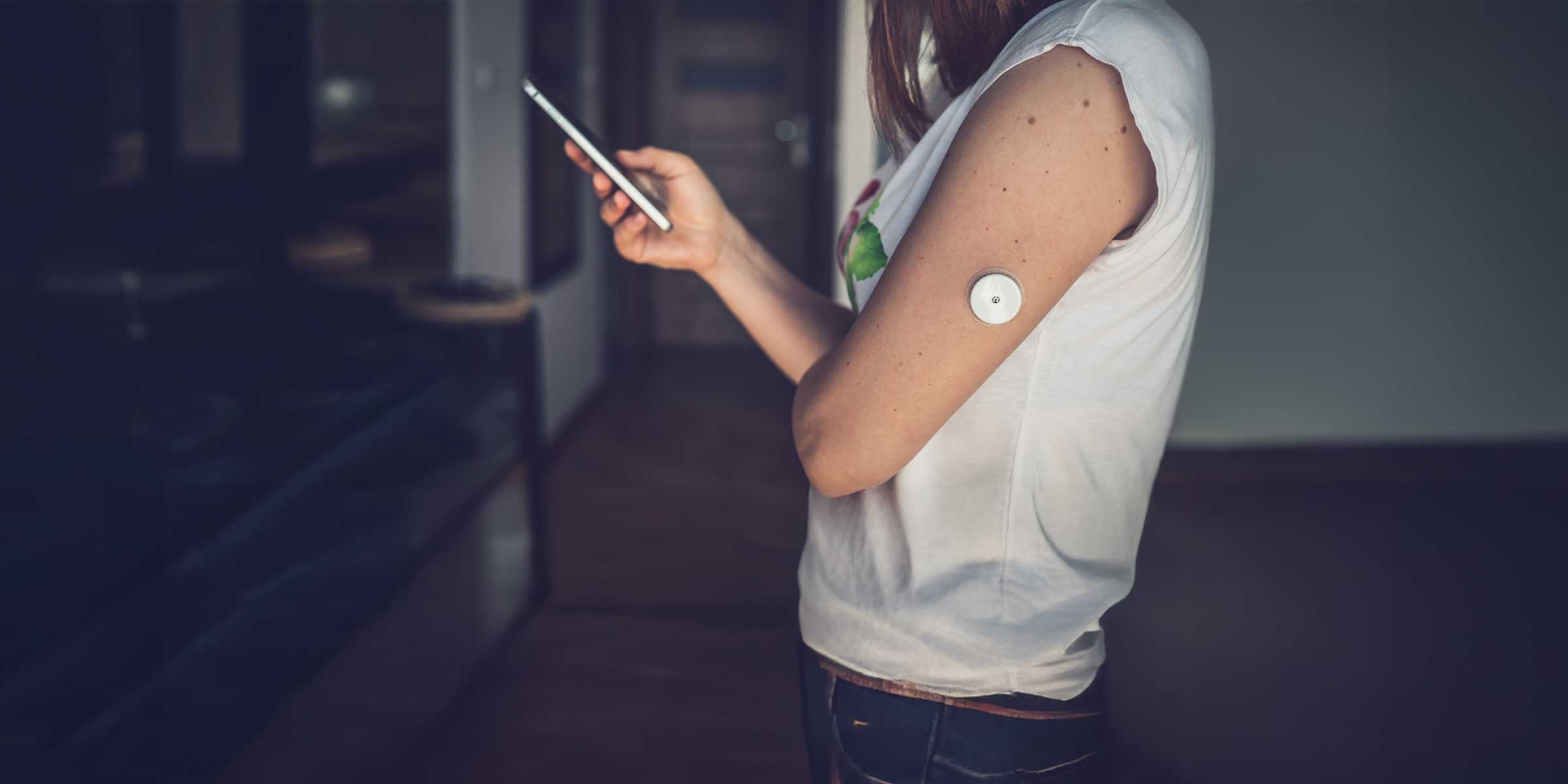 Woman checking results of Continuous Glucose Monitor on her phone
