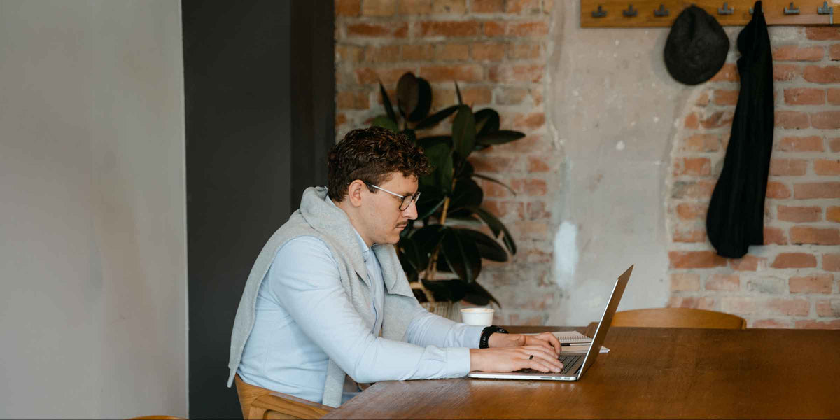 Man on laptop at his dining room table
