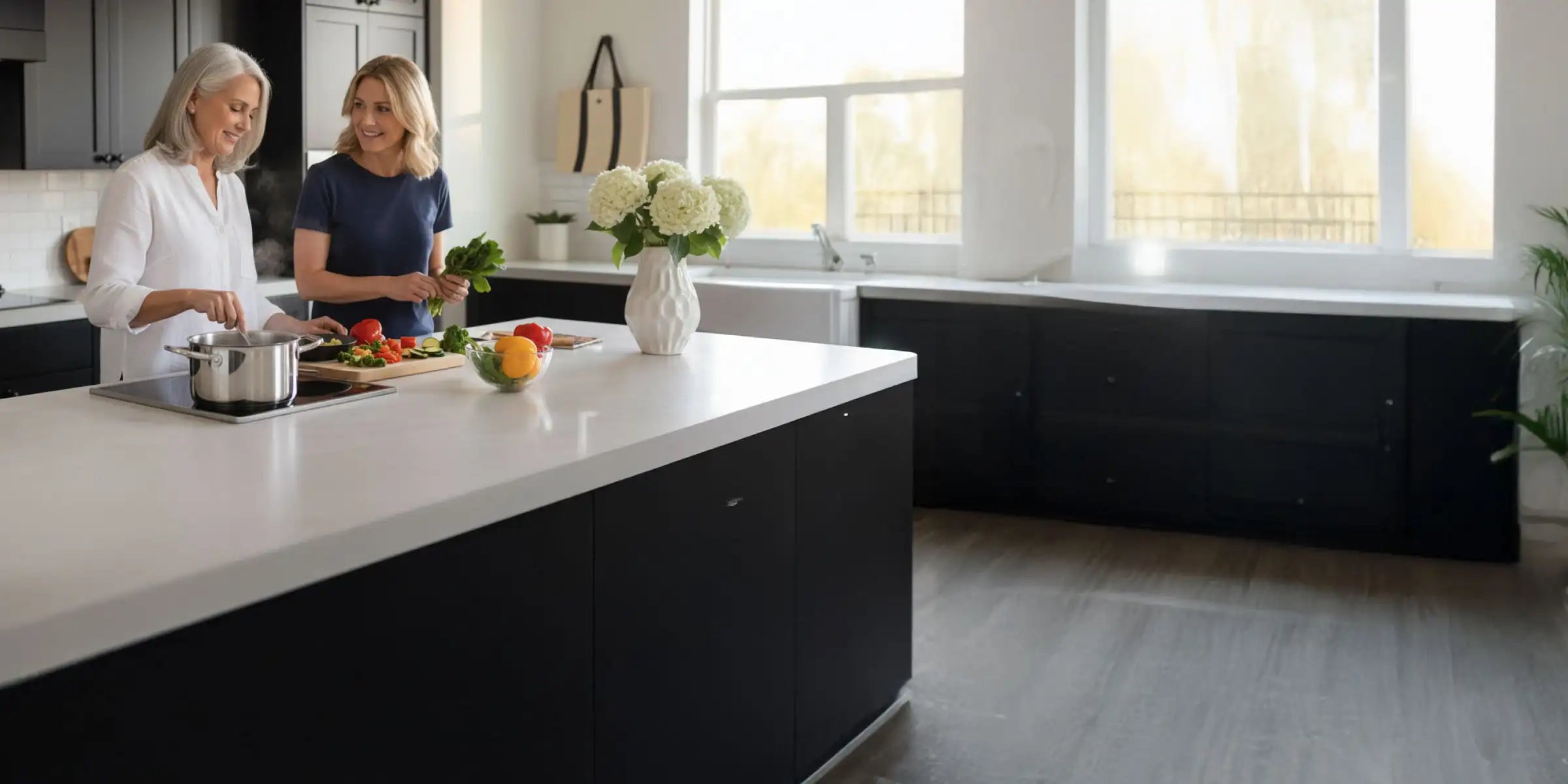 Older woman and her daughter cooking vegetables in a modern kitchen