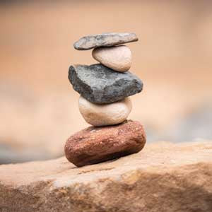 Stack of balanced stones on a rock with a blurred natural background